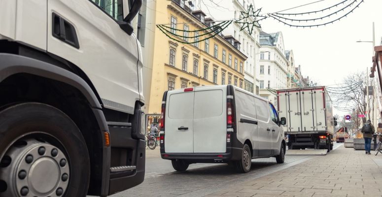 Białe samochody dostawcze, ulica w centrum miasta
